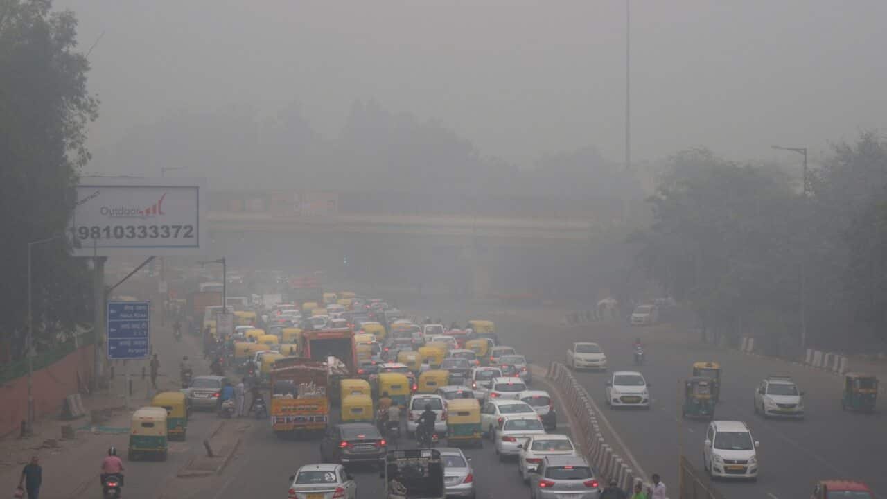Vehicles wait for a signal at a crossing as the city enveloped in smog in New Delhi, India (AAP)