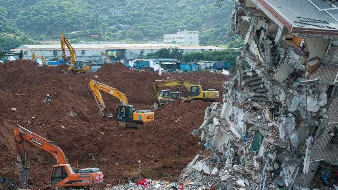 Excavators are used to dig through mud at the site of the landslide, which hit the Hengtaiyu, Liuxi and Dejicheng industrial parks, in Hongao village, Shenzhen city