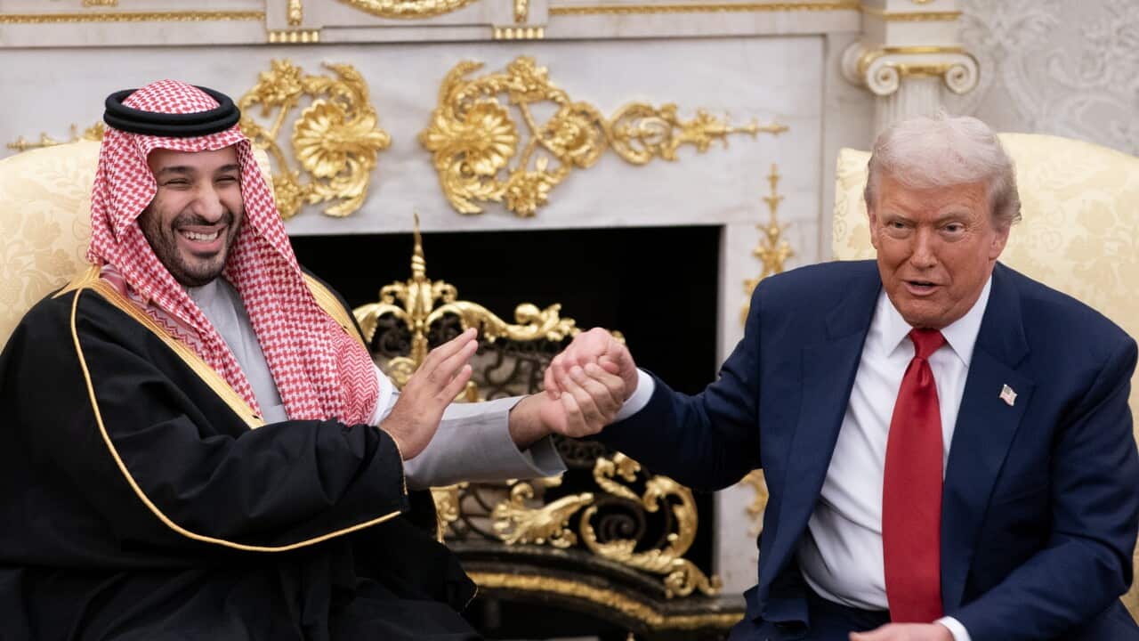 Two men shake hands in gold room