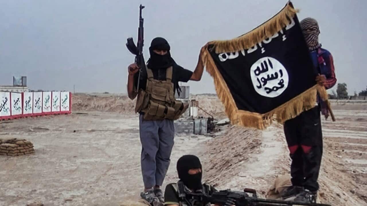 Militants pose with a jihadist flag after seizing an army checkpoint