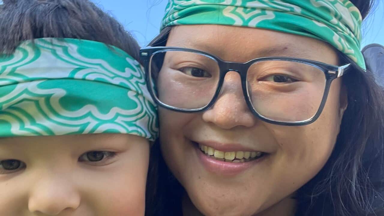 A very close-up shot of a woman and a 7-year-old boy both smiling and wearing green and white headbands