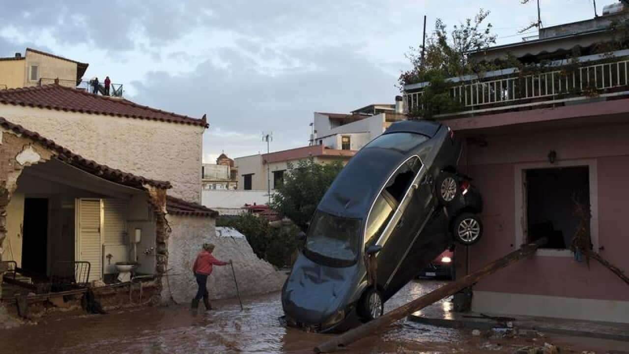 Flooded streets, damaged houses and a flipped over car in Mandra