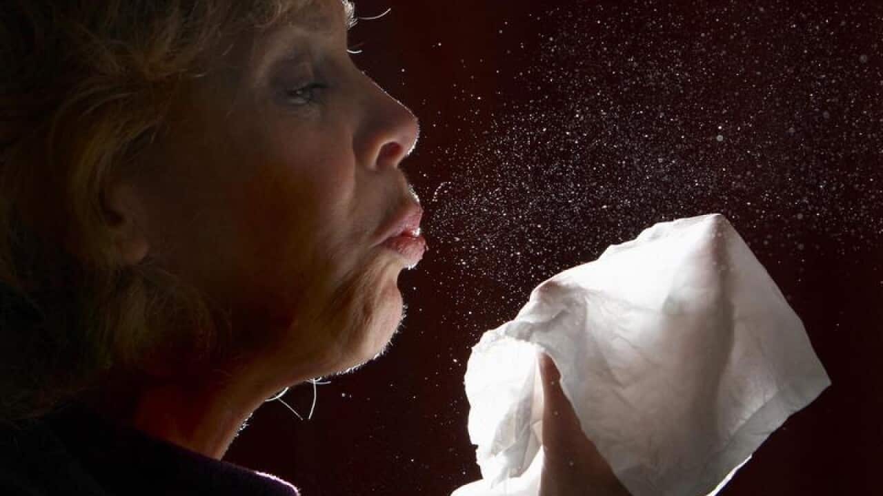 A woman sneezing.