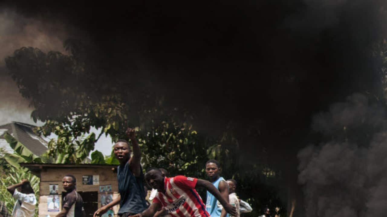 Protesters walk near the electoral commission in Beni during a demonstration against the postponement of elections in the territory of the Beni and the city of Butembo on December 27, 2018 (Getty Images)