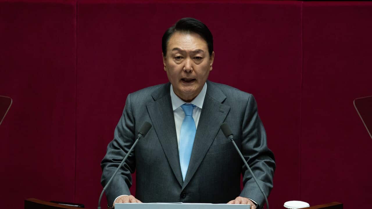 A man seen speaking at a microphone.
