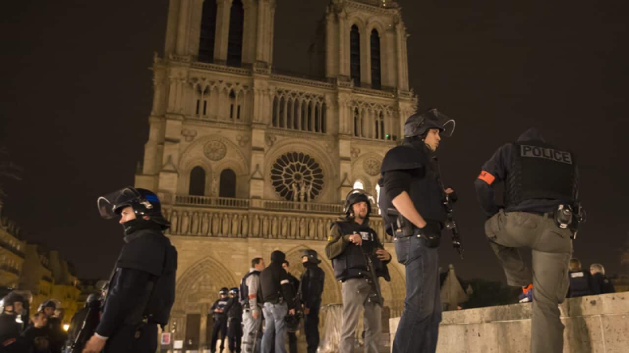Armed police officers go on foot patrol around Notre-Dame cathedral