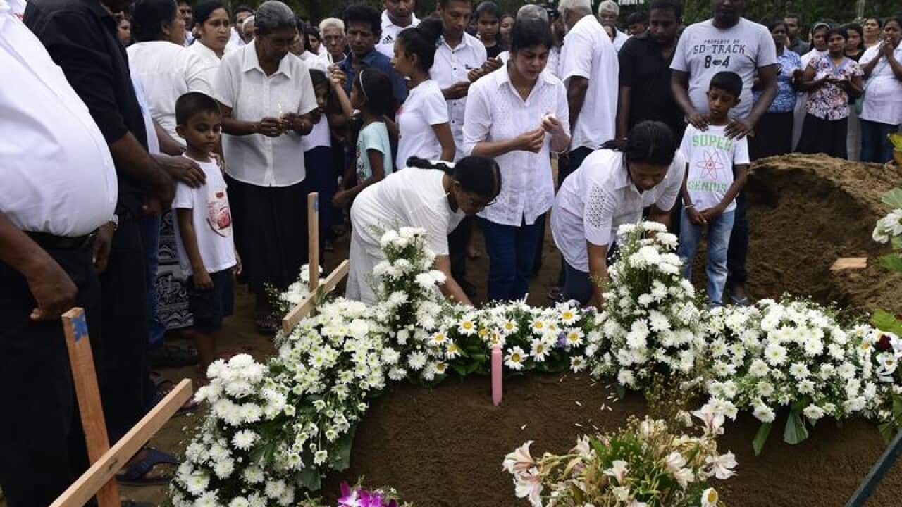 The family of a victim mourns at a graveside