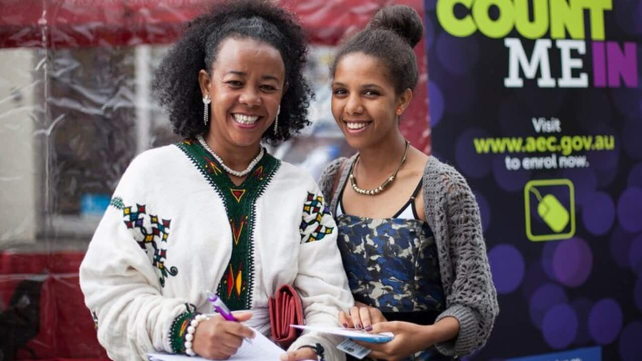 Two women, who are new citizens, enrolling to vote.