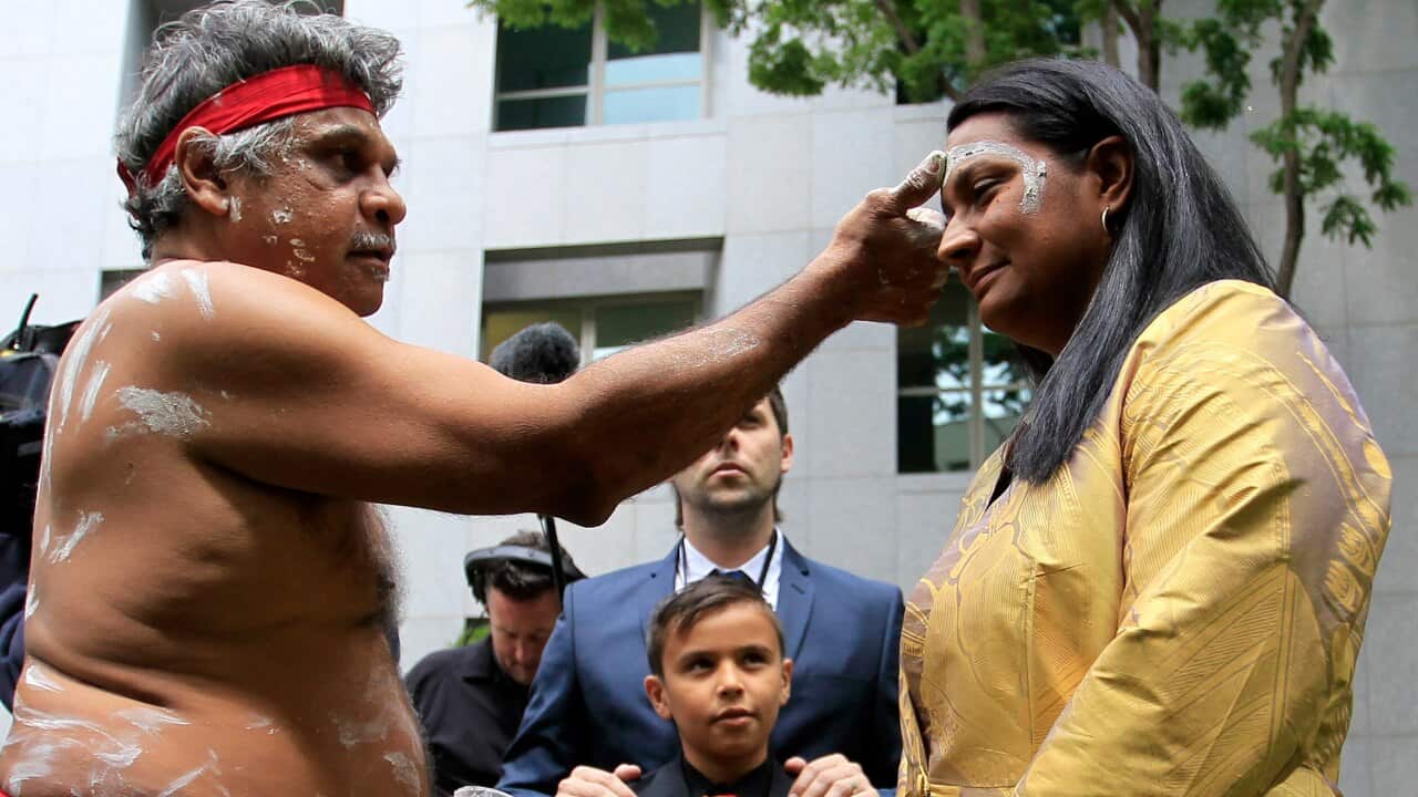 Senator Nova Peris receives an Aboriginal blessing at Parliament House in Canberra, Wednesday, Nov. 13, 2013. (AAP Image/Daniel Munoz) NO ARCHIVING