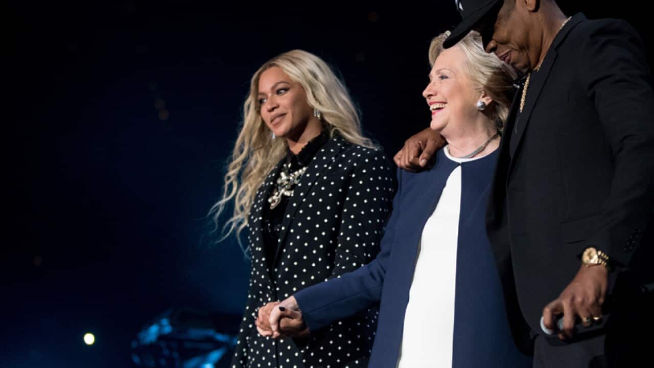 Hillary Clinton (C) with artists Jay Z and Beyonce (R)