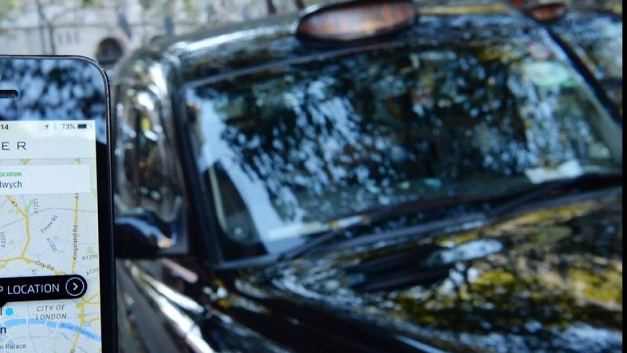 The Uber app next to taxis on Fleet Street in London