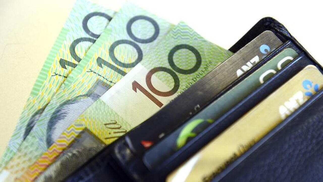 $100 Australian dollar notes pop out of a wallet with credit cards, pictured in Brisbane, Tuesday, Aug. 20, 2013. (AAP Image/Dan Peled) NO ARCHIVING