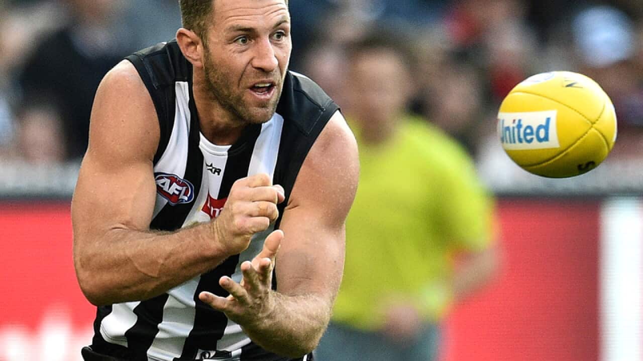 Travis Cloke of the Magpies handballs