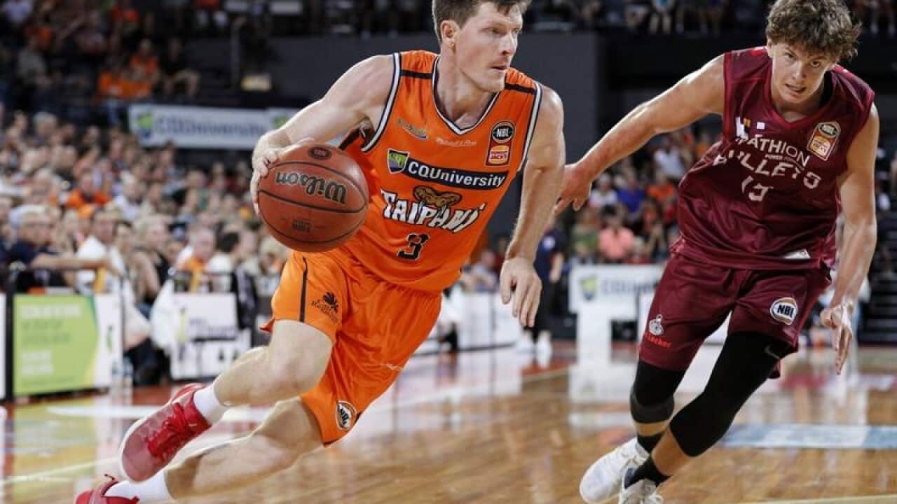 Cameron Gliddon of the Taipans (left) drives to the basket