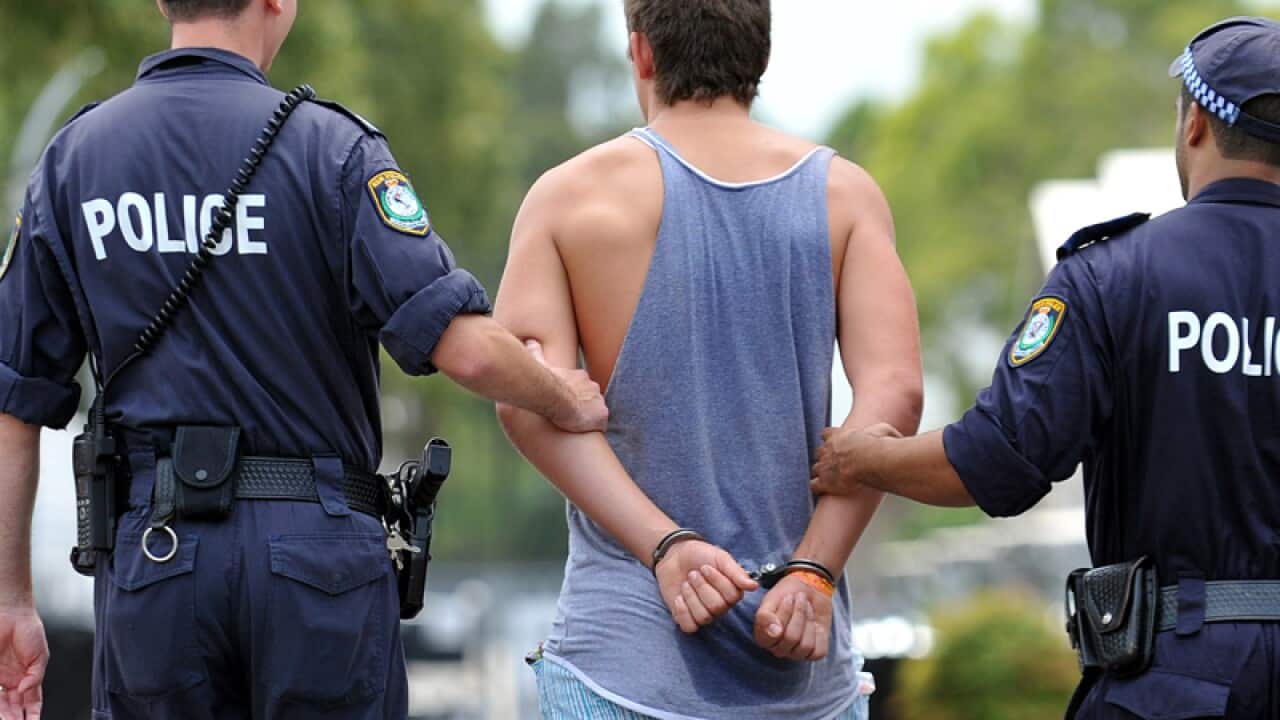 Police officers escort a patron