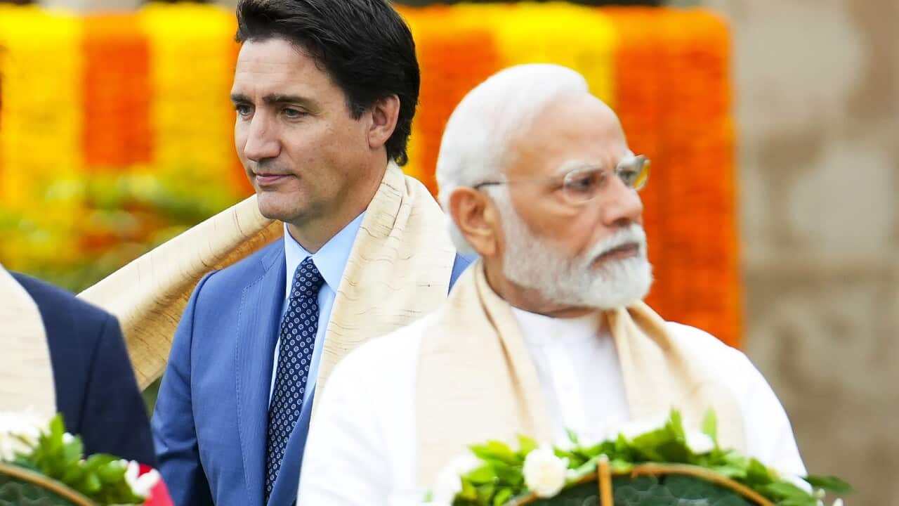 Justin Trudeau walks past Narendra Modi.