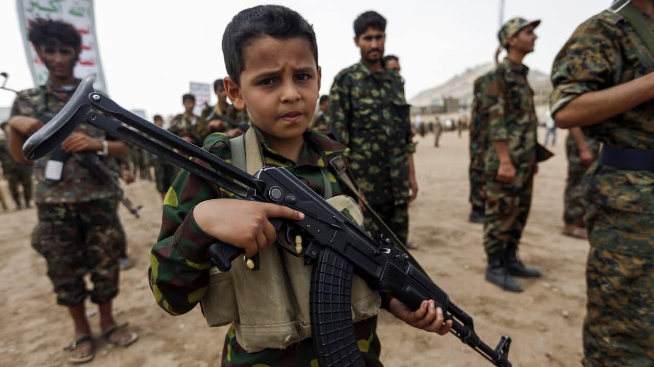 A Yemeni boy poses with a Kalashnikov assault rifle during a gathering of newly-recruited Houthi fighters in Sanaa,Yemen.