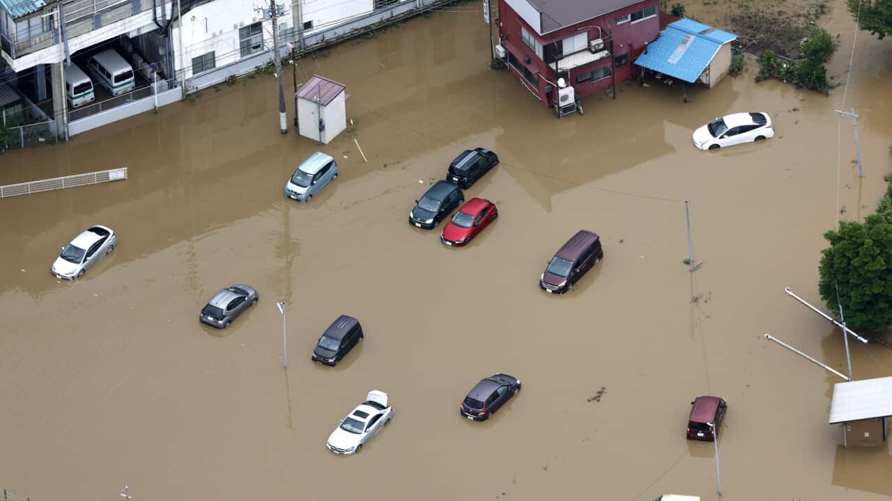 Cars submerged in brown flood water
