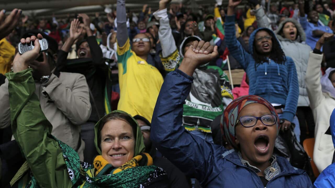 People shout out and punch the air during the memorial service