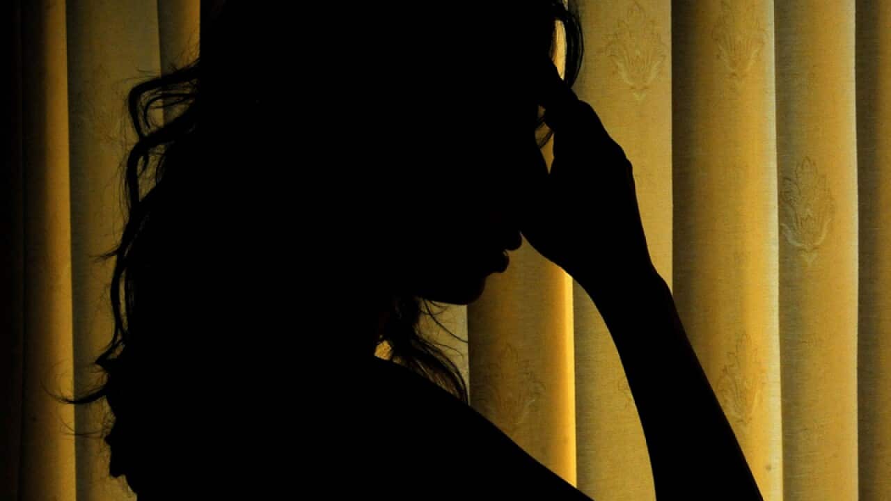 A woman holding her head.