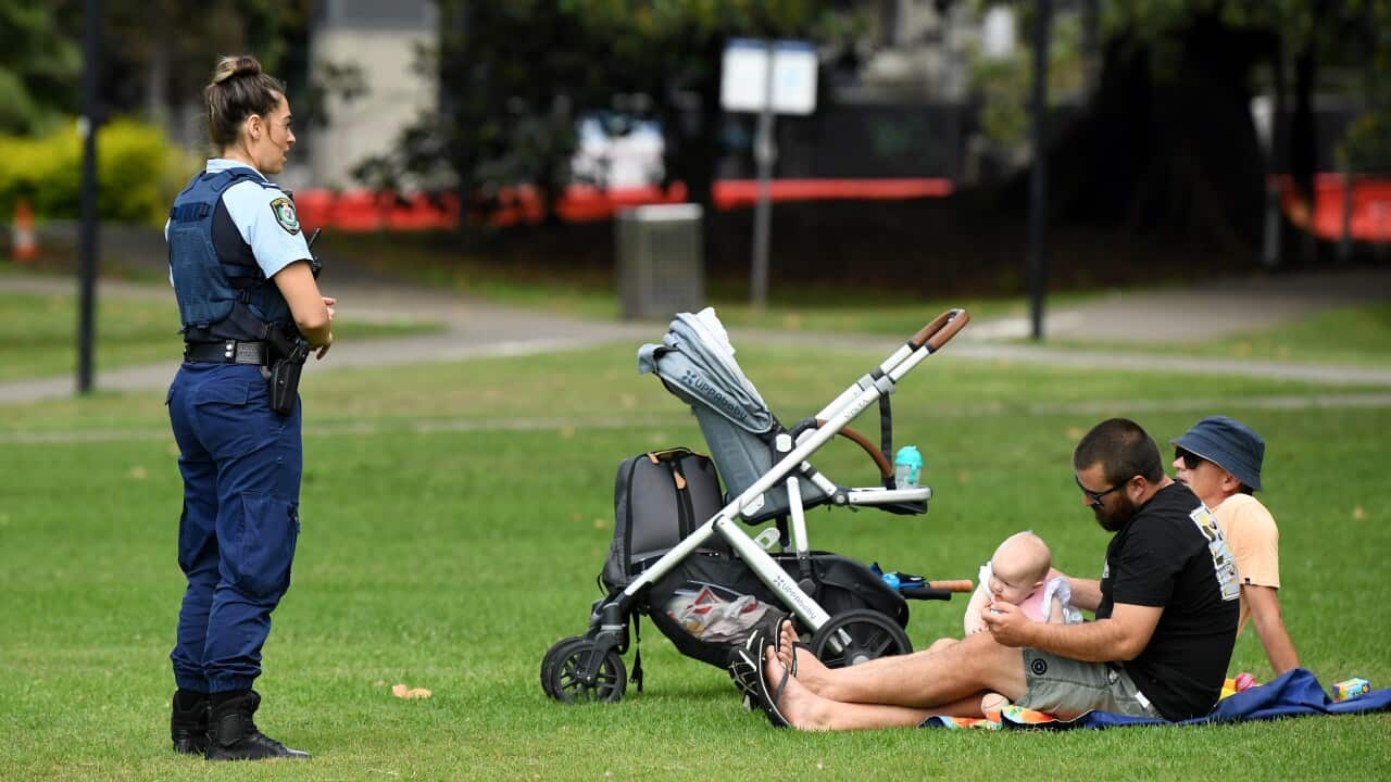 NSW Police officers ask a family to move on while on patrol at Rushcutters Bay park in Sydney, Wednesday, April 1, 2020.
