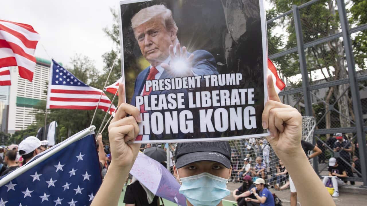 Anti-government protesters carry US national flags and placards that appeal to President Trump to 'liberate Hong Kong' during a rally