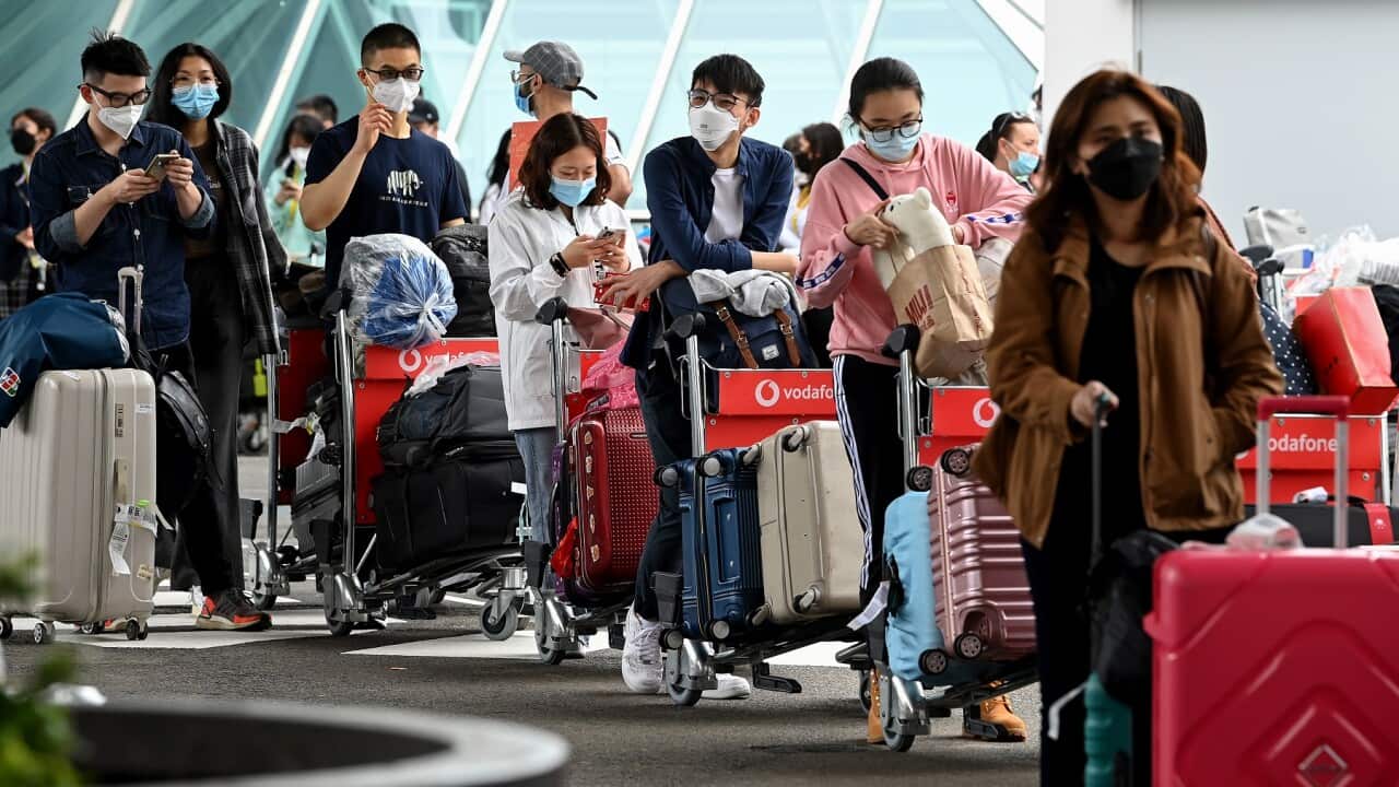 International students wear face masks as they arrive at Sydney Airport in Sydney, Monday, December 6, 2021. A pilot program to return international students to the state starts on Monday, with up to 250 students expected to arrive on a charter flight bef