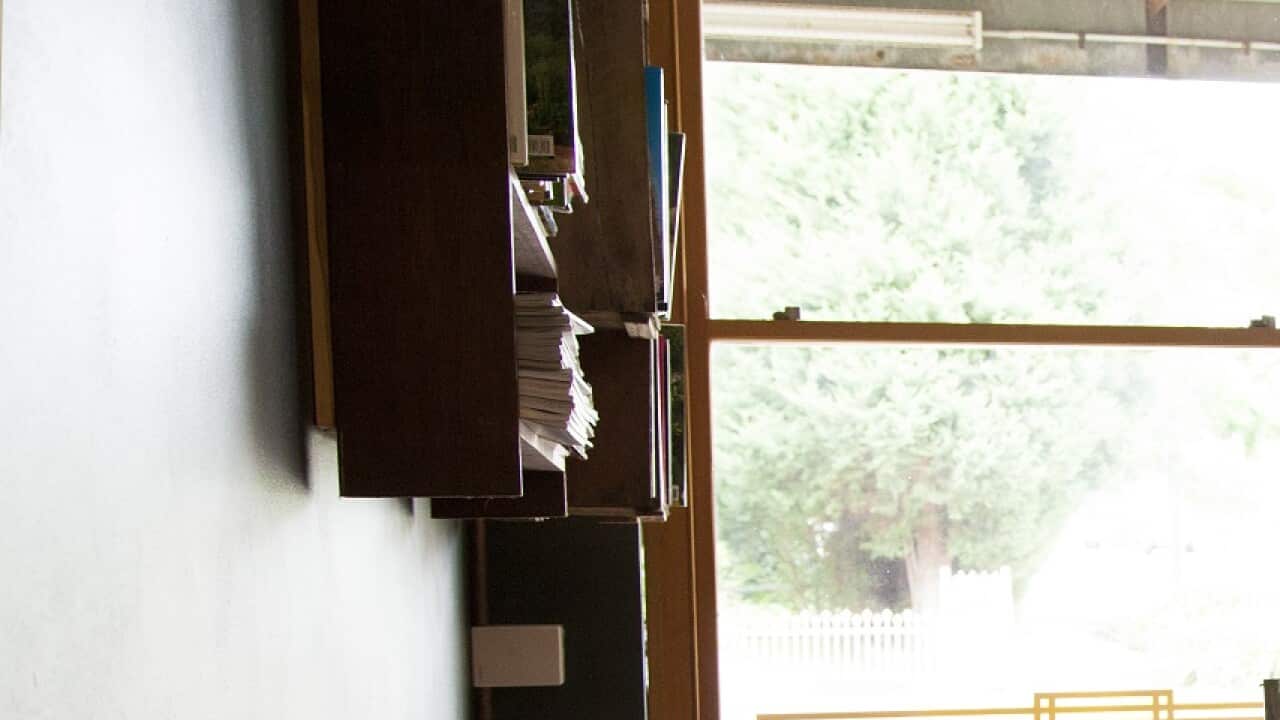 Waiter packing up cafe or restaurant chairs