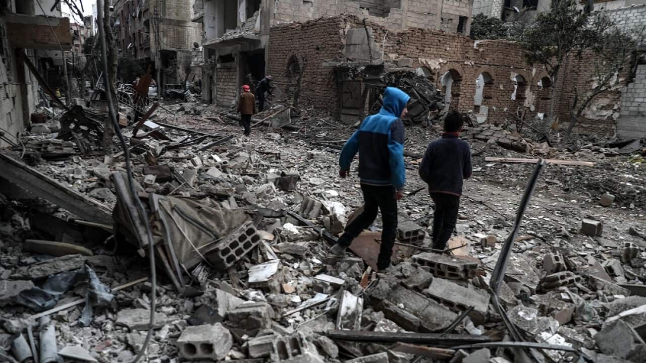 People inspect the rubble of damaged buildings after several airstrikes a day earlier, rebels-held Douma, Eastern Ghouta.