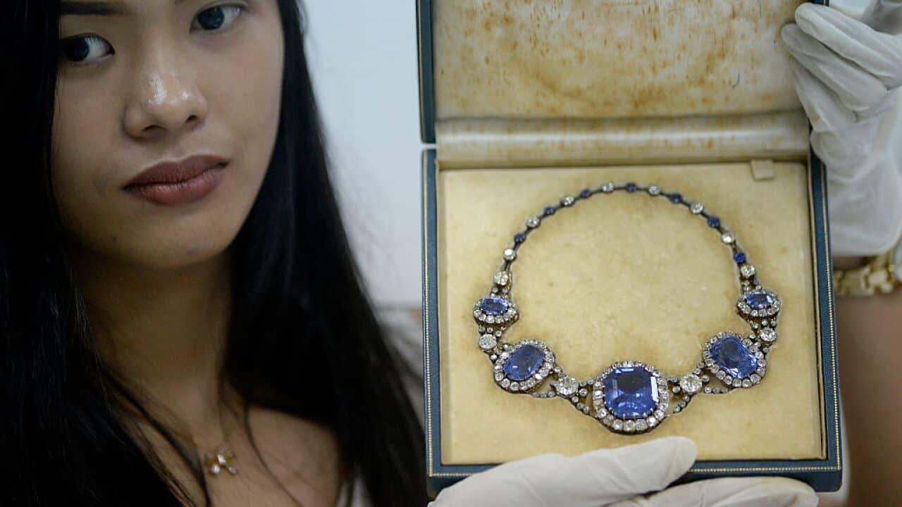 An official from the Presidential Commission on Good Government shows a piece of jewellery seized by the Philippine government from former first lady Imelda Marcos, at the Central Bank headquarters in Manila.