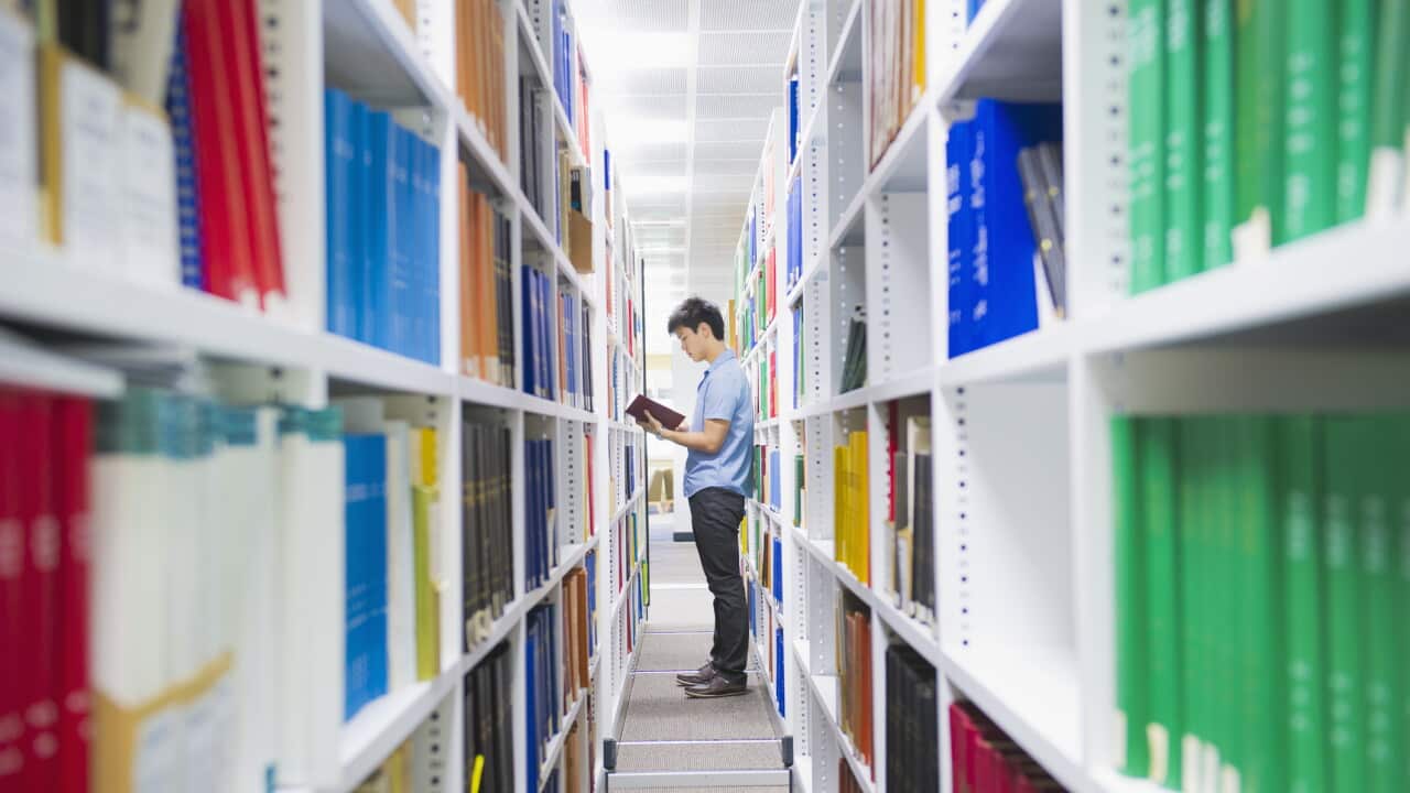 Man holding book in library
