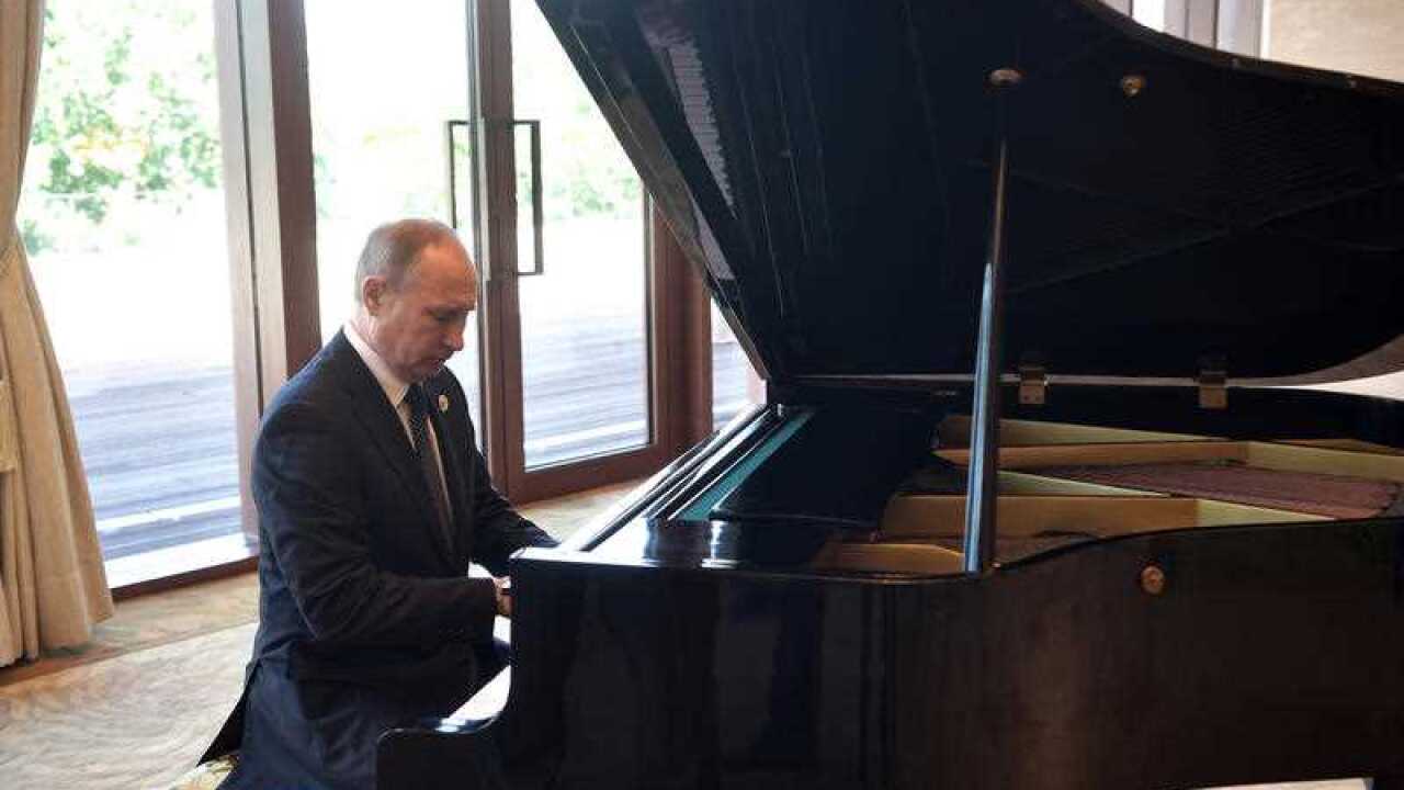 Russian President Vladimir Putin plays piano before his talks with Chinese President Xi Jinping