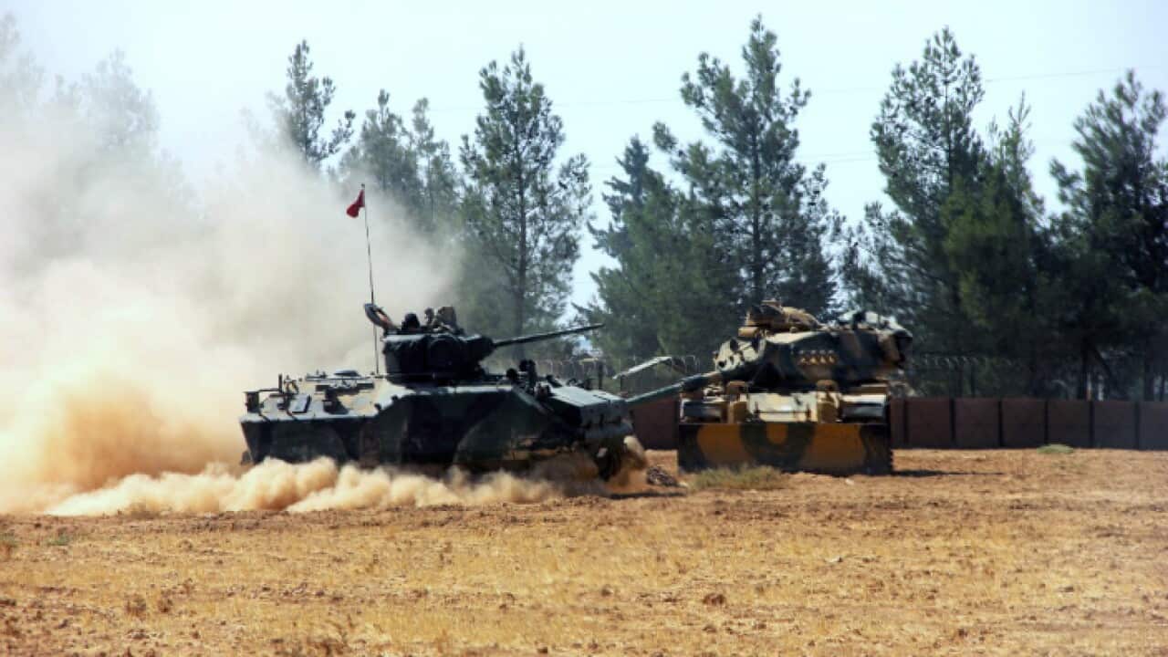 A Turkish army tank and an armoured vehicle are stationed near the border with Syria, in Karkamis, Turkey