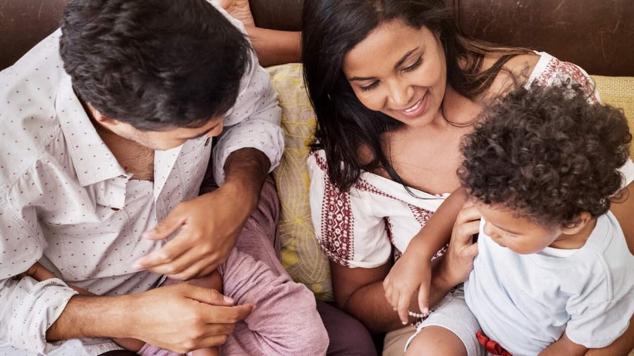 Parents having fun with children on sofa at home