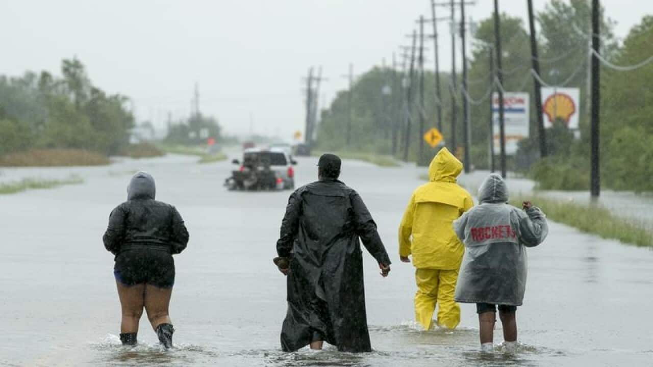 People walk through floodwaters in Beaumont, Texas