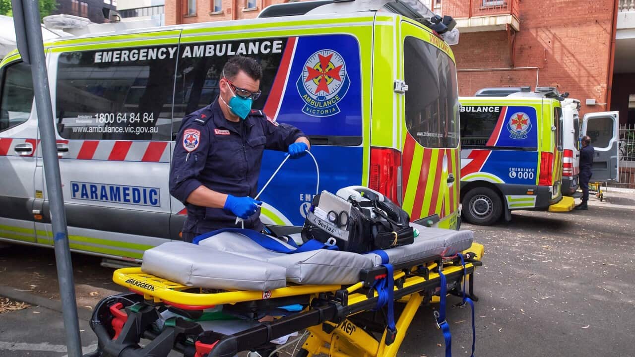 A paramedic moves equipment near an ambulance outside St Vincent's Hospital in Melbourne.