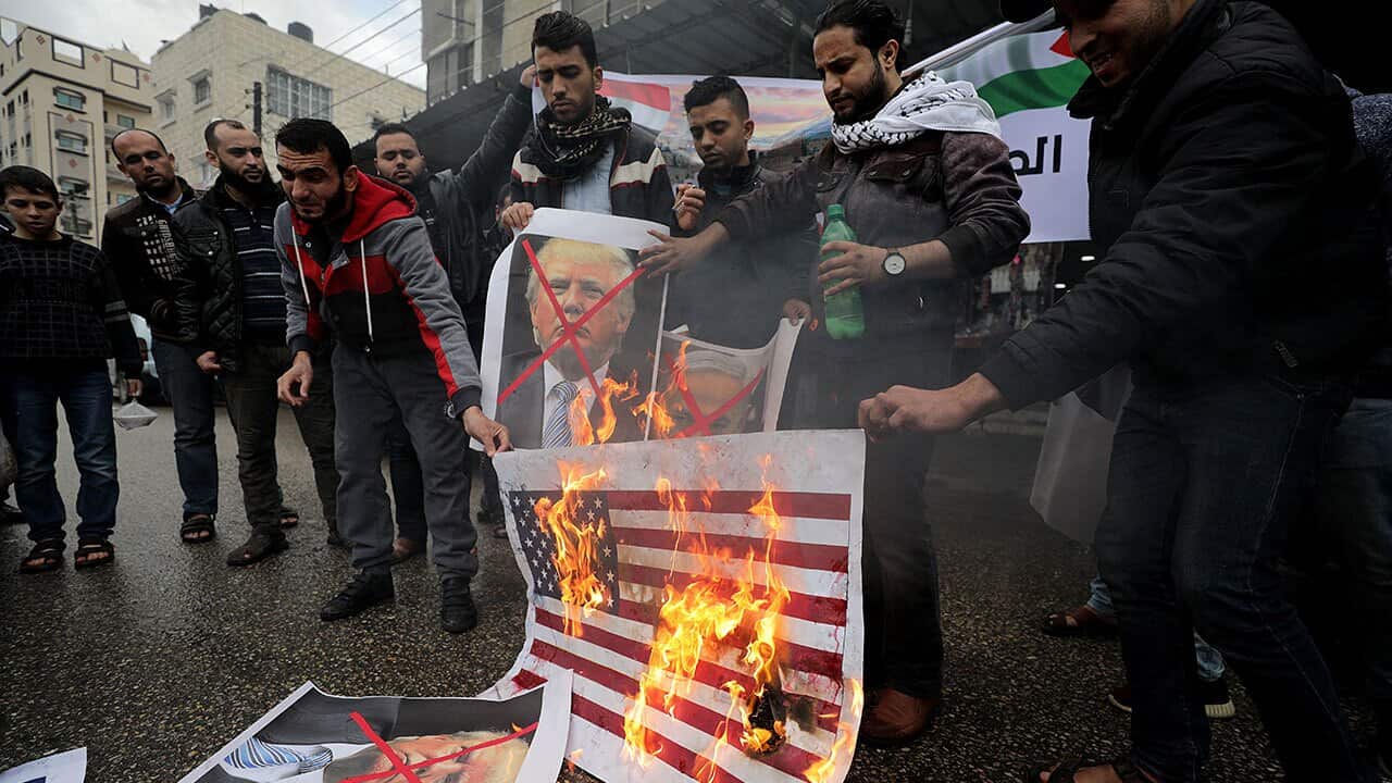 Palestinians burn Israeli and US flags and posters of US President Donald Trump and Israeli Prime Minister Benjamin Netanyahu during protest.