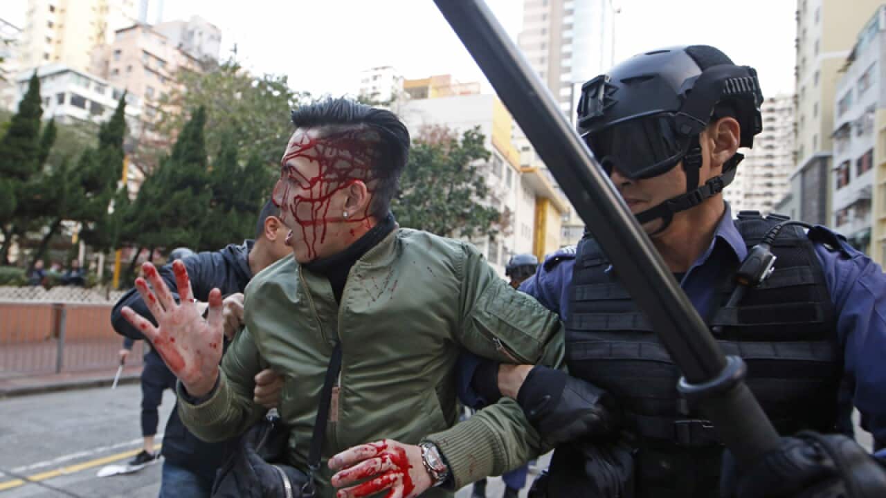 A rioter is taken away by police on a street in Mongkok
