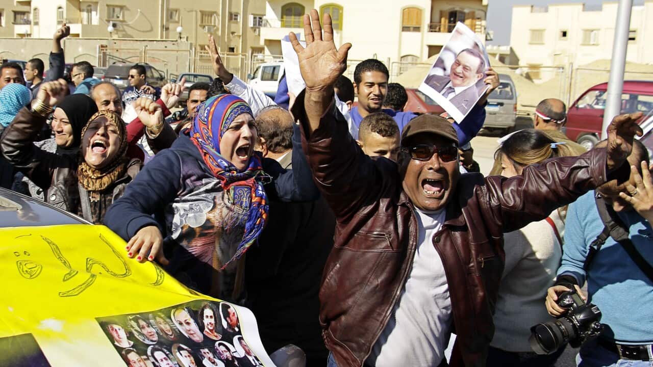 Supporters of former Egyptian President Hosni Mubarak celebrate after hearing the verdict of his trial outside a police academy on the outskirts of Cairo, Saturday, Nov. 29, 2014. (AAP)