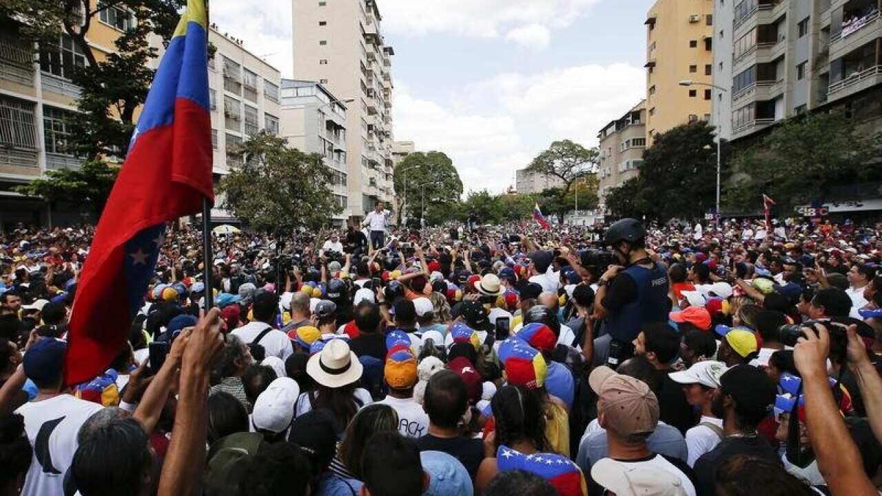 Supporters listen as Juan Guaido speaks at the rally