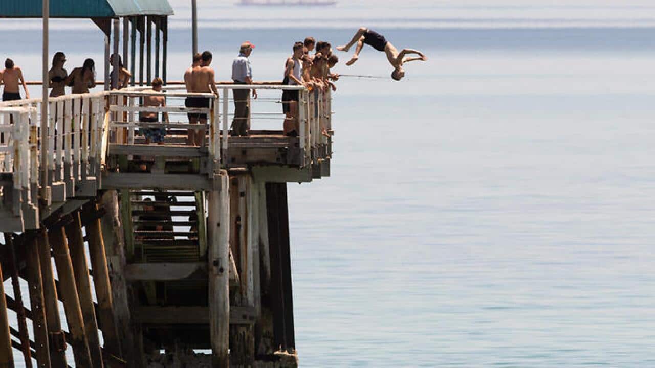 Jetty Jumpers escape the heat by cooling off at Henley Beach, 15 minutes west of Adelaide as temperatures rose above 42 degrees in the city of Adelaide. Thursday, Dec. 17, 2015. (AAP Image/Ben Macmahon) NO ARCHIVING