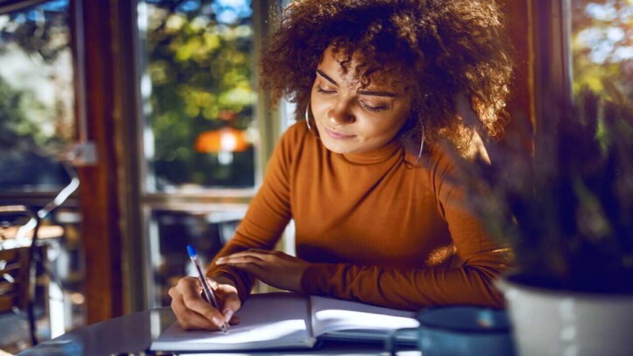 Portrait of a woman writing in a notebook