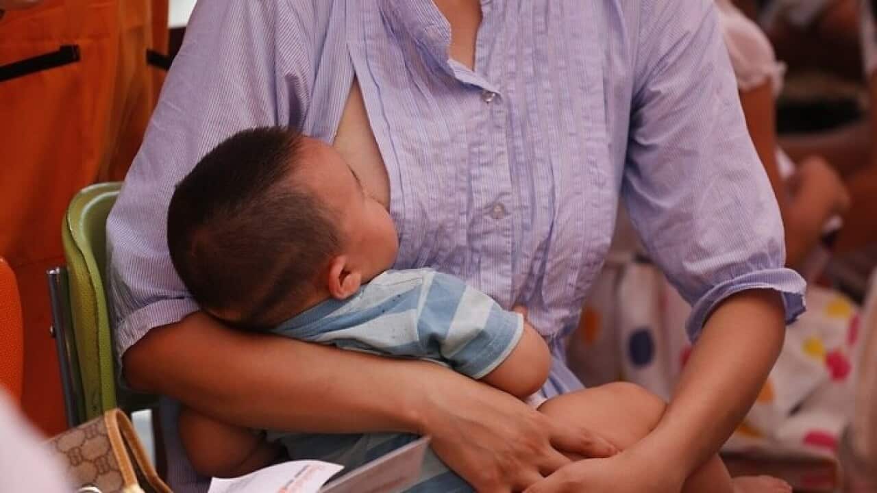 A mother breast feeds her baby