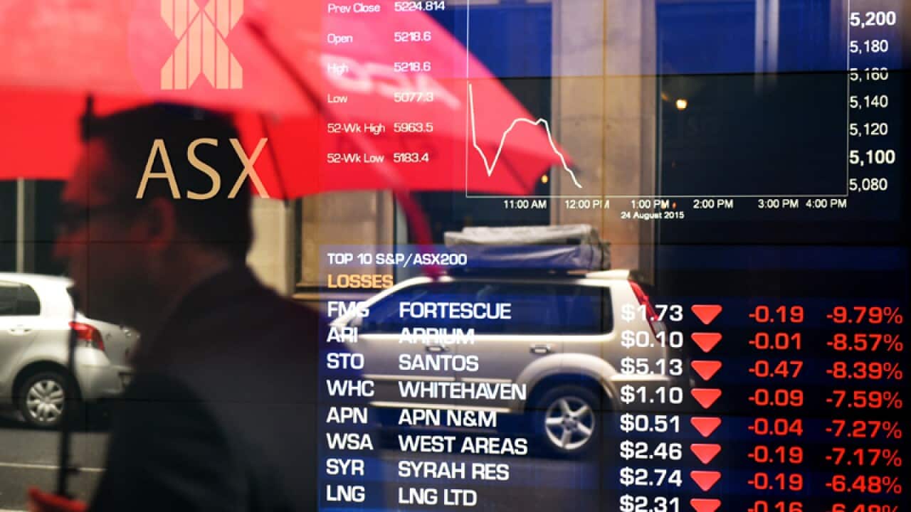 A man is seen in a reflection at the Australian Stock Exchange