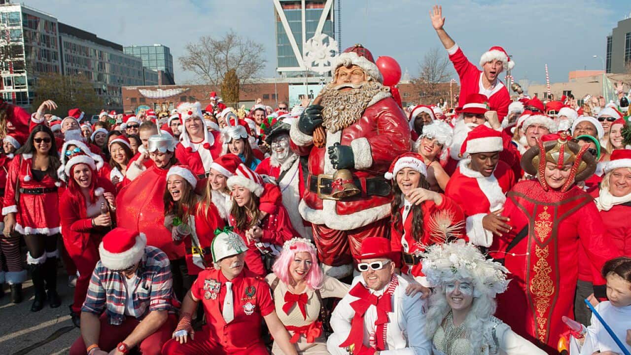 A crowd of people dressed as Santa gather for a group photo during the annual SantaCon pub crawl December 12, 2015 in the Brooklyn borough of New York City.