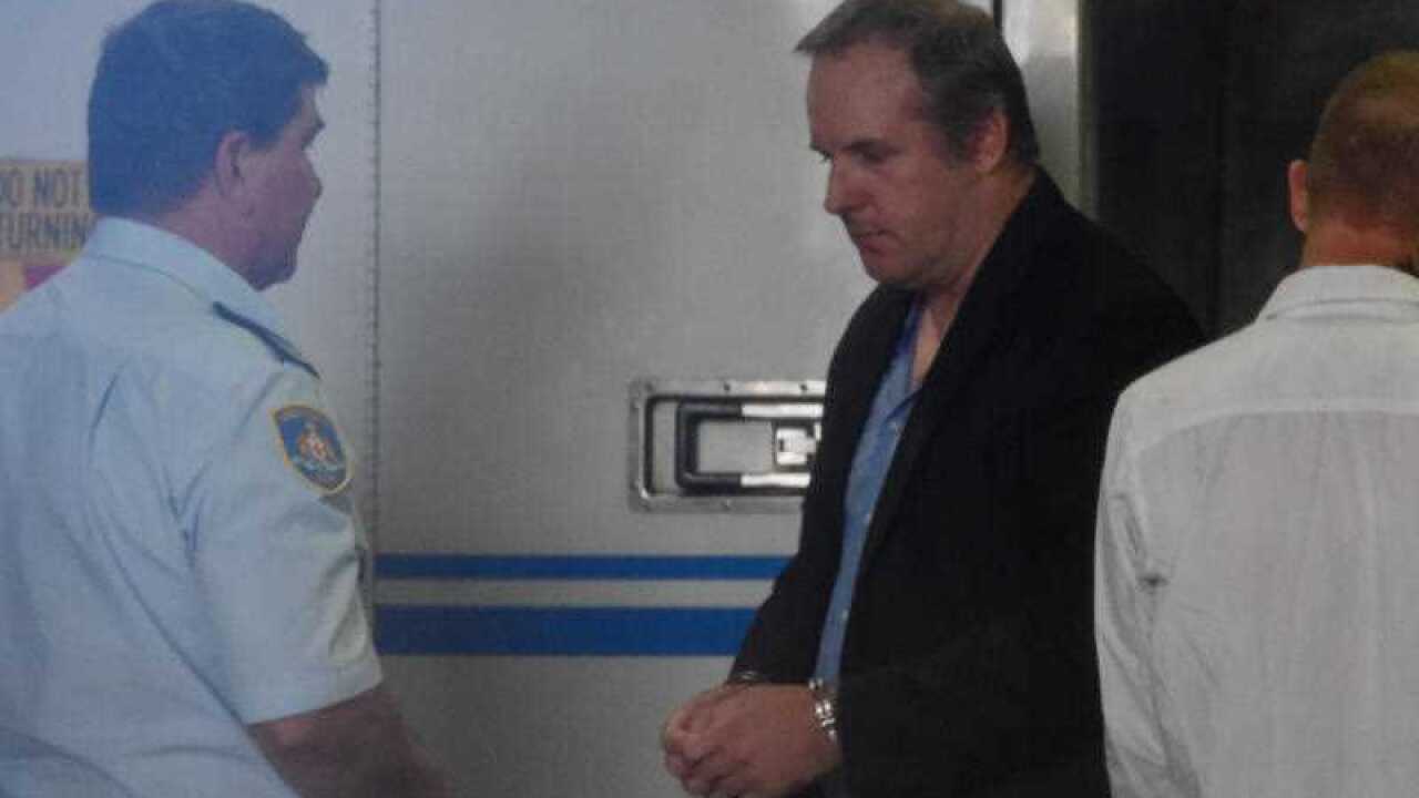 Former dance studio director Grant Davies is unloaded from a Corrective Services van at Burwood Local court, in Sydney, Monday, Dec. 15, 2014.