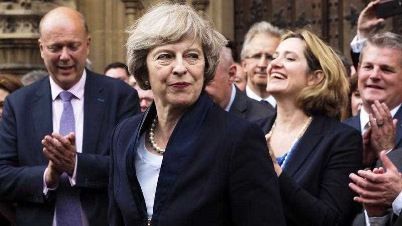 Britain's Theresa May is applauded by Conservative Party members of parliament outside the Houses of Parliament in London