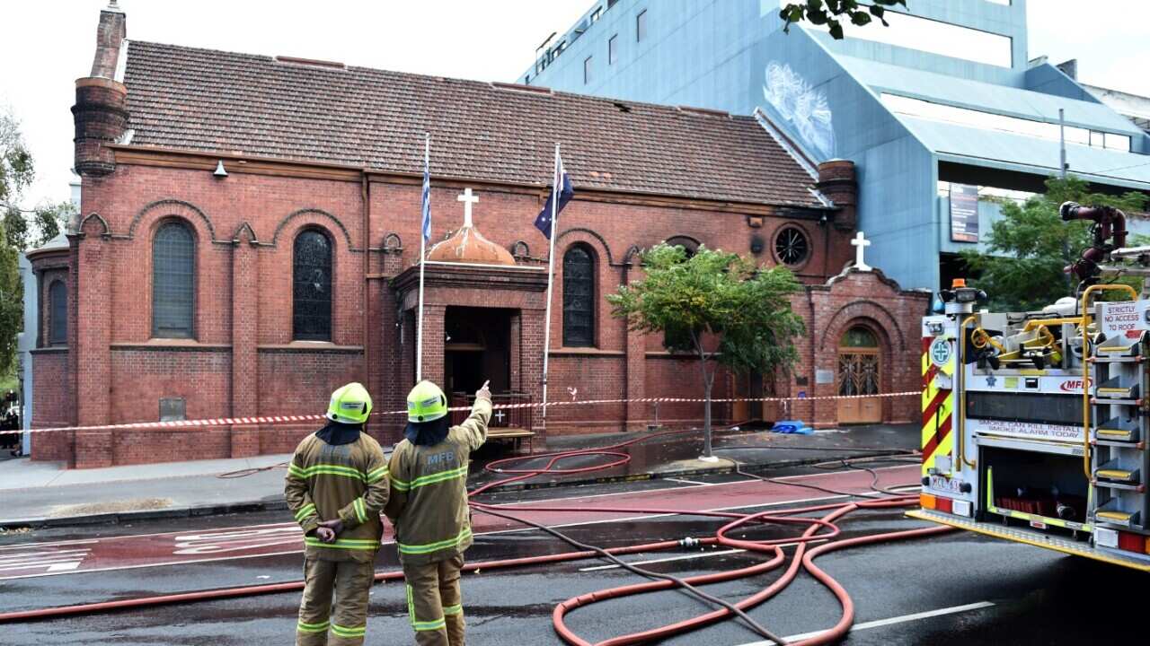 Firefighters survey the scene of a fire at the Annunciation of Our lady Greek Orthodox Church in Melbourne, Monday, May 2, 2016.