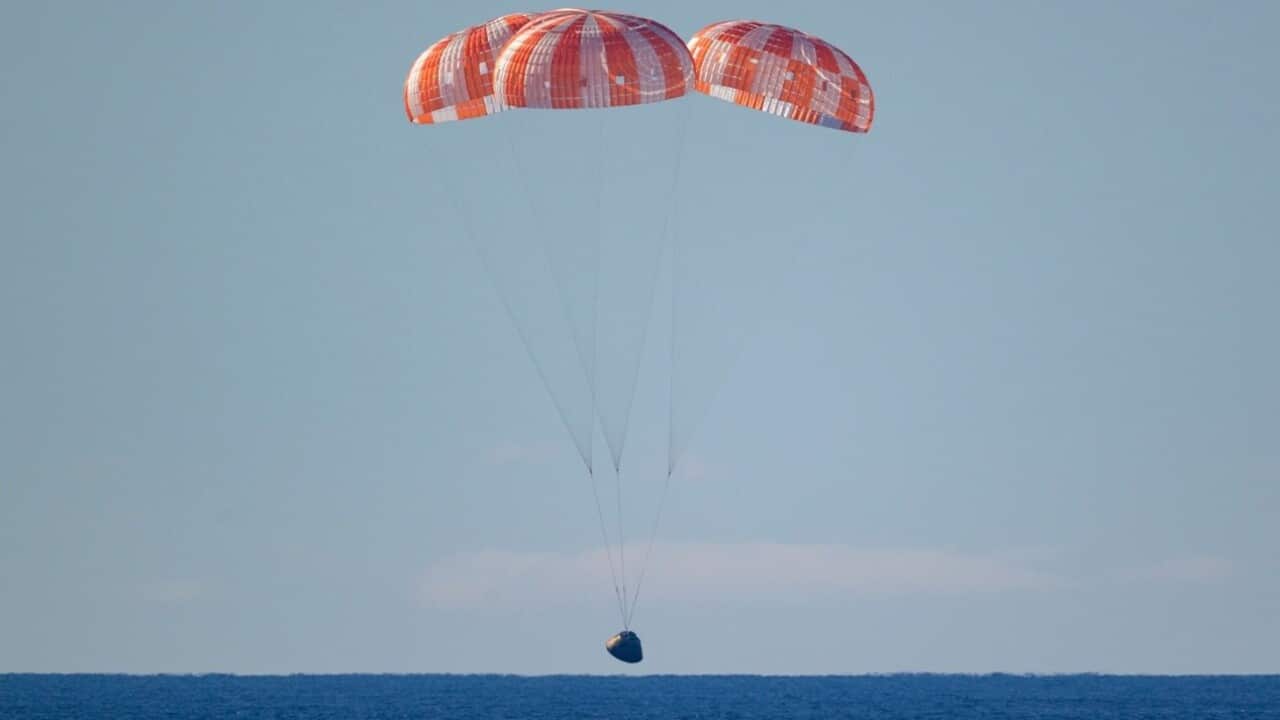 In this photo provided by NASA, the Orion spacecraft with Artemis II crewmembers aboard approaches the surface of the Pacific Ocean for splashdown off the coast of California.jpg