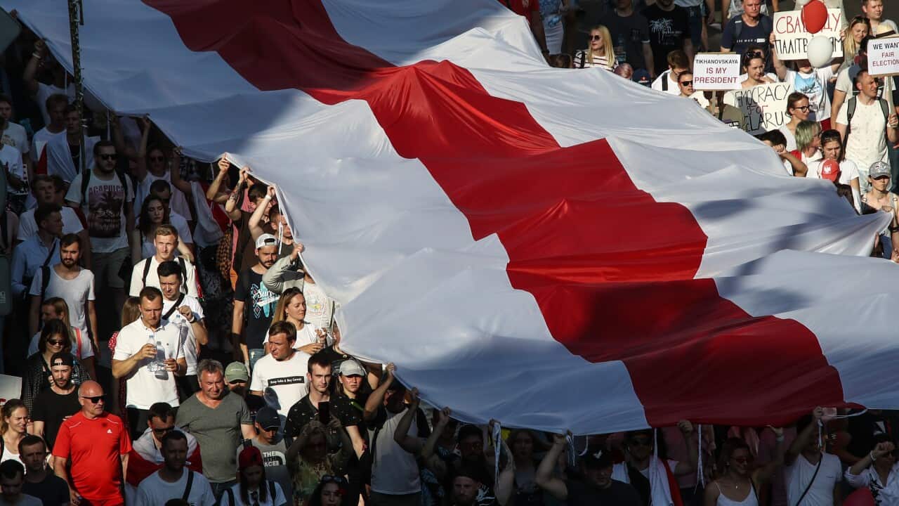 People stretch out a white-red-white flag during a protest against the 2020 Belarusian presidential election results